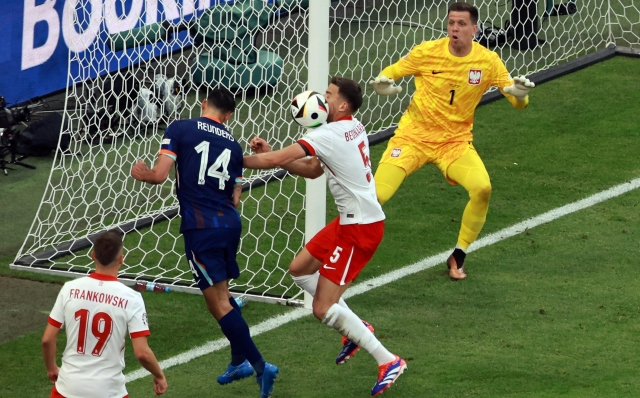 epa11415198 Tijjani Reijnders of the Netherlands (2L) in action against Jan Bednarek of Poland (2R) as goalkeeper Wojciech Szczesny of Poland (R) looks on during the UEFA EURO 2024 group D match between Poland and Netherlands, in Hamburg, Germany, 16 June 2024.  EPA/CLEMENS BILAN
