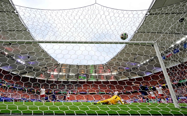 Netherlands' forward #09 Wout Weghorst (R) scores his team's second goal during the UEFA Euro 2024 Group D football match between Poland and the Netherlands at the Volksparkstadion in Hamburg on June 16, 2024. (Photo by JOHN MACDOUGALL / AFP)