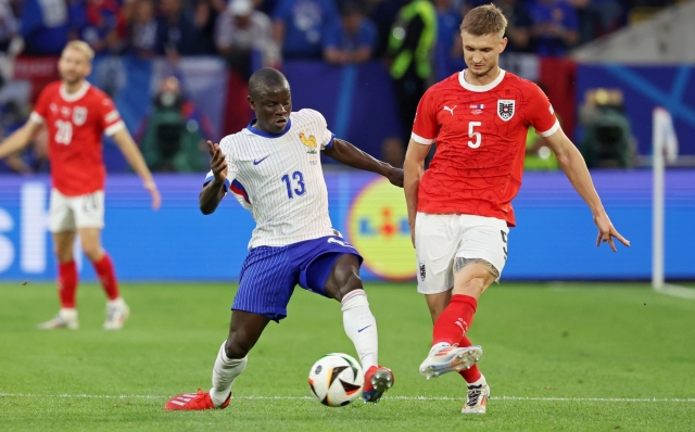 epa11418724 N'Golo Kante (L) of Frannce and Stefan Posch (R) of Austria during the UEFA EURO 2024 group D soccer match between Austria and France, in Dusseldorf, Germany, 17 June 2024.  EPA/CHRISTOPHER NEUNDORF