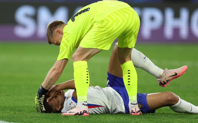 DUSSELDORF, GERMANY - JUNE 17: Patrick Pentz of Austria consoles Kylian Mbappe of France as he lies on the floor whilst holding his face after clashing heads with Kevin Danso of Austria (not pictured) during the UEFA EURO 2024 group stage match between Austria and France at Düsseldorf Arena on June 17, 2024 in Dusseldorf, Germany. (Photo by Dean Mouhtaropoulos/Getty Images)