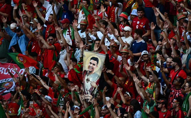TOPSHOT - Supporters of Portugal hold an image of Portugal's forward #07 Cristiano Ronaldo in the tribune prior to the UEFA Euro 2024 Group F football match between Portugal and the Czech Republic at the Leipzig Stadium in Leipzig on June 18, 2024. (Photo by GABRIEL BOUYS / AFP)