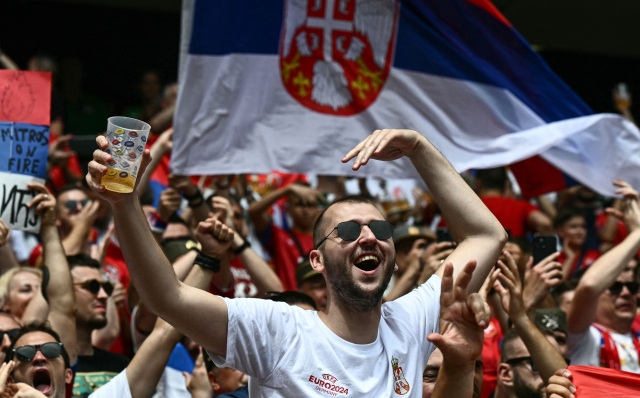 Fans of Serbia waves national flags prior to the UEFA Euro 2024 Group C football match between Slovenia and Serbia at the Munich Football Arena in Munich, southern Germany, on June 20, 2024. (Photo by Fabrice COFFRINI / AFP)
