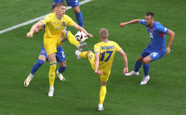 DUSSELDORF, GERMANY - JUNE 21: Artem Dovbyk and Oleksandr Zinchenko of Ukraine challenge for a loose ball under pressure from Peter Pekarik of Slovakia (obscured) during the UEFA EURO 2024 group stage match between Slovakia and Ukraine at Düsseldorf Arena on June 21, 2024 in Dusseldorf, Germany. (Photo by Lars Baron/Getty Images)