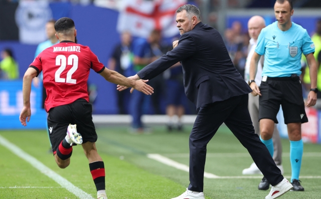 Georgia's French head coach Willy Sagnol (C) greets Georgia's forward #22 Georges Mikautadze (L) after the team's first goal during the UEFA Euro 2024 Group F football match between Georgia and the Czech Republic at the Volksparkstadion in Hamburg on June 22, 2024. (Photo by Ronny HARTMANN / AFP)