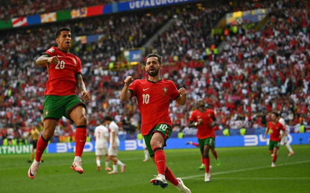 Portugal's midfielder #10 Bernardo Silva (C) celebrates scoring his team's first goal with Portugal's defender #20 Joao Cancelo (L) during the UEFA Euro 2024 Group F football match between Turkey and Portugal at the BVB Stadion in Dortmund on June 22, 2024. (Photo by OZAN KOSE / AFP)