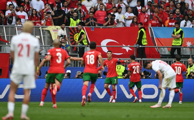 Portugal's forward #07 Cristiano Ronaldo (C) celebrates with teammates after setting up the third goal for Portugal's midfielder #08 Bruno Fernandes during the UEFA Euro 2024 Group F football match between Turkey and Portugal at the BVB Stadion in Dortmund on June 22, 2024. (Photo by OZAN KOSE / AFP)