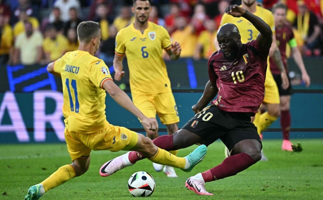 Romania's defender #11 Nicusor Bancu and Belgium's forward #10 Romelu Lukaku vie during the UEFA Euro 2024 Group E football match between Belgium and Romania at the Cologne Stadium in Cologne on June 22, 2024. (Photo by JAVIER SORIANO / AFP)