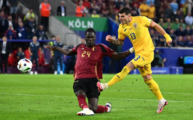 Romania's forward #13 Valentin Mihaila (R) kicks the ball past Belgium's midfielder #24 Amadou Onana during the UEFA Euro 2024 Group E football match between Belgium and Romania at the Cologne Stadium in Cologne on June 22, 2024. (Photo by Alberto PIZZOLI / AFP)