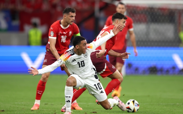 FRANKFURT AM MAIN, GERMANY - JUNE 23: Jamal Musiala of Germany reacts as he is challenged by Fabian Rieder of Switzerland during the UEFA EURO 2024 group stage match between Switzerland and Germany at Frankfurt Arena on June 23, 2024 in Frankfurt am Main, Germany. (Photo by Alexander Hassenstein/Getty Images)