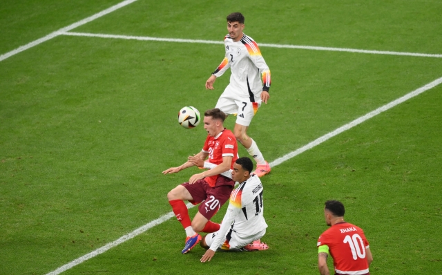 FRANKFURT AM MAIN, GERMANY - JUNE 23: Michel Aebischer of Switzerland is challenged by Jamal Musiala of Germany during the UEFA EURO 2024 group stage match between Switzerland and Germany at Frankfurt Arena on June 23, 2024 in Frankfurt am Main, Germany. (Photo by Justin Setterfield/Getty Images)