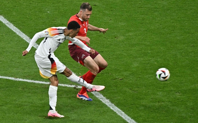 Germany's midfielder #10 Jamal Musiala shoots but misses an attempt to score against Switzerland's defender #03 Silvan Widmer during the UEFA Euro 2024 Group A football match between Switzerland and Germany at the Frankfurt Arena in Frankfurt am Main on June 23, 2024. (Photo by JAVIER SORIANO / AFP)