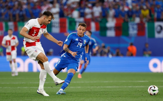 Croatia's defender #03 Marin Pongracic shoots the ball next to Italy's forward #19 Mateo Retegui during the UEFA Euro 2024 Group B football match between Croatia and Italy at the Leipzig Stadium in Leipzig on June 24, 2024. (Photo by Odd ANDERSEN / AFP)