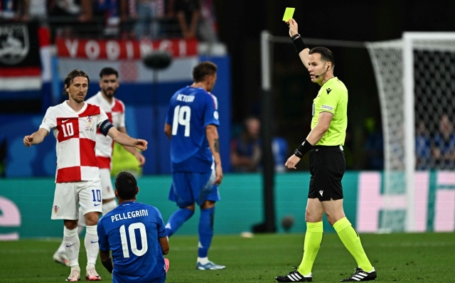 Dutch referee Danny Makkelie (R) shows a yellow card to Croatia's midfielder #25 Luka Susic (unseen) during the UEFA Euro 2024 Group B football match between Croatia and Italy at the Leipzig Stadium in Leipzig on June 24, 2024. (Photo by GABRIEL BOUYS / AFP)