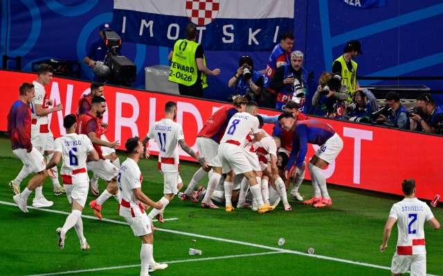 Croatia's midfielder #10 Luka Modric celebrates with teammates scoring his team's first goal during the UEFA Euro 2024 Group B football match between the Croatia and Italy at the Leipzig Stadium in Leipzig on June 24, 2024. (Photo by JOHN MACDOUGALL / AFP)