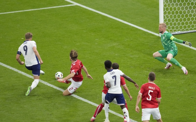 England's Harry Kane, left, scores the opening goal during a Group C match between Denmark and England at the Euro 2024 soccer tournament in Frankfurt, Germany, Thursday, June 20, 2024. (AP Photo/Darko Vojinovic)