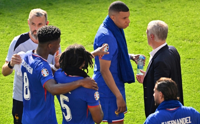 France's players including (From L) France's midfielder #08 Aurelien Tchouameni, France's forward #10 Kylian Mbappe and France's defender #05 Jules Kounde discuss with France's head coach Didier Deschamps during a drink break during the UEFA Euro 2024 Group D football match between France and Poland at the BVB Stadion in Dortmund on June 25, 2024. (Photo by INA FASSBENDER / AFP)