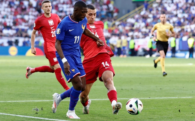 France's forward #11 Ousmane Dembele (C) is tackled by Poland's defender #14 Jakub Kiwior (R) in the penalty area during the UEFA Euro 2024 Group D football match between France and Poland at the BVB Stadion in Dortmund on June 25, 2024. (Photo by KENZO TRIBOUILLARD / AFP)