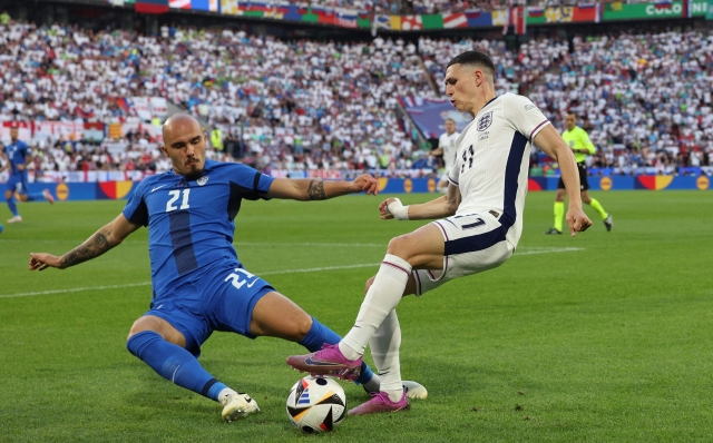 Slovenia's defender #21 Vanja Drkusic fights for the ball with England's midfielder #11 Phil Foden during the UEFA Euro 2024 Group C football match between England and Slovenia at the Cologne Stadium in Cologne on June 25, 2024. (Photo by Adrian DENNIS / AFP)