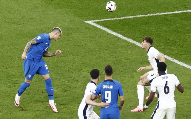 epa11437572 Benjamin Sesko (L) of Slovenia in action during the UEFA EURO 2024 group C soccer match between England and Slovenia, in Cologne, Germany, 25 June 2024.  EPA/MOHAMMED BADRA