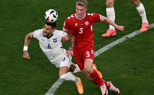 (From L) Serbia's midfielder #06 Nemanja Gudelj fights for the ball with Denmark's forward #09 Rasmus Hojlund during the UEFA Euro 2024 Group C football match between Denmark and Serbia at the Munich Football Arena in Munich on June 25, 2024. (Photo by Fabrice COFFRINI / AFP)
