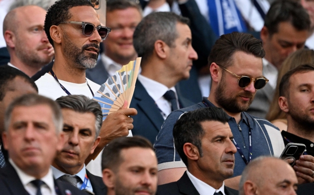 Former English international footballer player Rio Ferdinand (L) attends the UEFA Euro 2024 Group C football match between England and Slovenia at the Cologne Stadium in Cologne on June 25, 2024. (Photo by Kirill KUDRYAVTSEV / AFP)