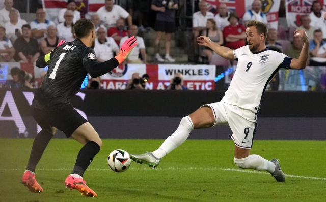 England's Harry Kane, right, is unable to get his boot on the ball as Slovenia's goalkeeper Jan Oblak defends during a Group C match between the England and Slovenia at the Euro 2024 soccer tournament in Cologne, Germany, Tuesday, June 25, 2024. (AP Photo/Frank Augstein)