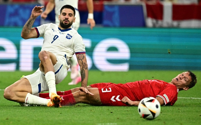 Serbia's forward #09 Aleksandar Mitrovic (L) fights for the ball with  Denmark's defender #03 Jannik Vestergaard during the UEFA Euro 2024 Group C football match between Denmark and Serbia at the Munich Football Arena in Munich on June 25, 2024. (Photo by Tobias SCHWARZ / AFP)