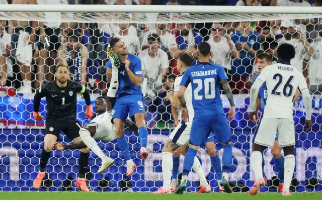 COLOGNE, GERMANY - JUNE 25: Bukayo Saka of England attempts an overhead kick whilst colliding with Andraz Sporar of Slovenia during the UEFA EURO 2024 group stage match between England and Slovenia at Cologne Stadium on June 25, 2024 in Cologne, Germany. (Photo by Alex Grimm/Getty Images)