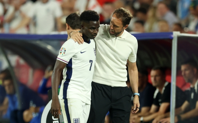 COLOGNE, GERMANY - JUNE 25: Bukayo Saka of England is embraced by Gareth Southgate, Head Coach of England, after being replaced by substitute Cole Palmer (not pictured) during the UEFA EURO 2024 group stage match between England and Slovenia at Cologne Stadium on June 25, 2024 in Cologne, Germany. (Photo by Richard Pelham/Getty Images)