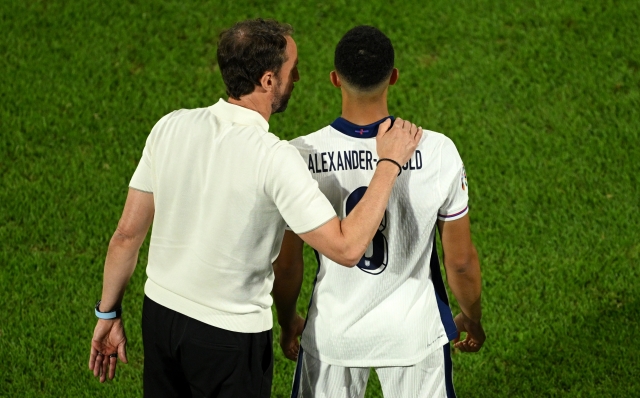 COLOGNE, GERMANY - JUNE 25: Gareth Southgate, Head Coach of England, speaks with Trent Alexander-Arnold of England as he prepares to come on as a substitute during the UEFA EURO 2024 group stage match between England and Slovenia at Cologne Stadium on June 25, 2024 in Cologne, Germany. (Photo by Matthias Hangst/Getty Images)