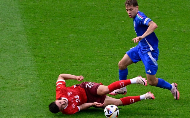 Switzerland's midfielder #26 Fabian Rieder (L) lies on the pitch after colliding with Italy's midfielder #18 Nicolo Barella during the UEFA Euro 2024 round of 16 football match between Switzerland and Italy at the Olympiastadion Berlin in Berlin on June 29, 2024. (Photo by JOHN MACDOUGALL / AFP)
