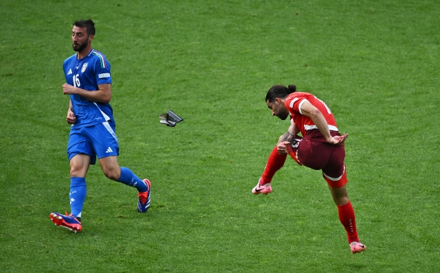 BERLIN, GERMANY - JUNE 29: Ricardo Rodriguez of Switzerland shoots as his shin pad falls off whilst under pressure from Bryan Cristante of Italy during the UEFA EURO 2024 round of 16 match between Switzerland and Italy at Olympiastadion on June 29, 2024 in Berlin, Germany. (Photo by Dan Mullan/Getty Images)