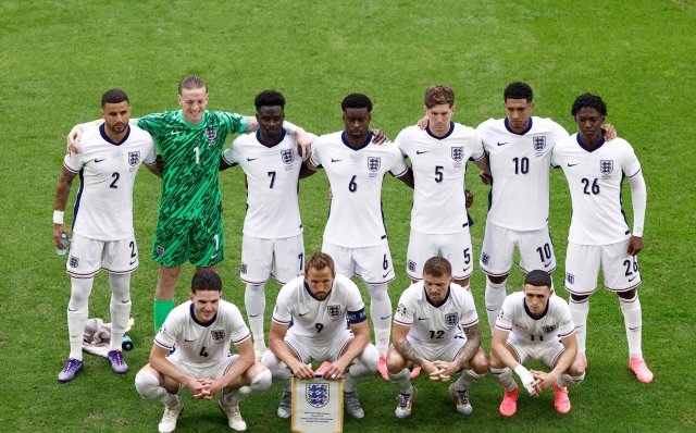 (From L) England's defender #02 Kyle Walker, England's goalkeeper #01 Jordan Pickford, England's midfielder #04 Declan Rice, England's forward #07 Bukayo Saka, England's forward #09 Harry Kane, England's defender #06 Marc Guehi, England's defender #12 Kieran Trippier, England's defender #05 John Stones, England's midfielder #10 Jude Bellingham, England's midfielder #11 Phil Foden and England's midfielder #26 Kobbie Mainoo pose for a group photo at the start of the UEFA Euro 2024 round of 16 football match between England and Slovakia at the Arena AufSchalke in Gelsenkirchen on June 30, 2024. (Photo by KENZO TRIBOUILLARD / AFP)