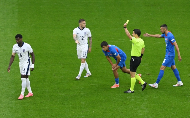 GELSENKIRCHEN, GERMANY - JUNE 30: Referee Umut Meler shows a yellow card to Norbert Gyomber of Slovakia (C) during the UEFA EURO 2024 round of 16 match between England and Slovakia at Arena AufSchalke on June 30, 2024 in Gelsenkirchen, Germany. (Photo by Shaun Botterill/Getty Images)