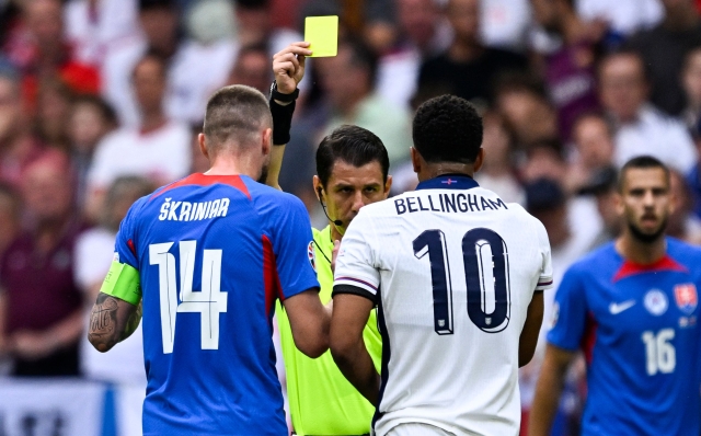 Turkish referee Umut Meler shows a yellow card to England's midfielder #10 Jude Bellingham during the UEFA Euro 2024 round of 16 football match between England and Slovakia at the Arena AufSchalke in Gelsenkirchen on June 30, 2024. (Photo by INA FASSBENDER / AFP)