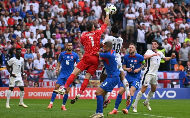 Slovakia's goalkeeper #01 Martin Dubravka punches the ball ahead of England's midfielder #10 Jude Bellingham during the UEFA Euro 2024 round of 16 football match between England and Slovakia at the Arena AufSchalke in Gelsenkirchen on June 30, 2024. (Photo by OZAN KOSE / AFP)