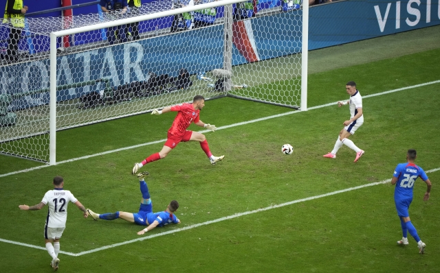 England's Phil Foden, right, scores a goal that was later disallowed for offside during a round of sixteen match between England and Slovakia at the Euro 2024 soccer tournament in Gelsenkirchen, Germany, Sunday, June 30, 2024. (AP Photo/Ebrahim Noroozi)