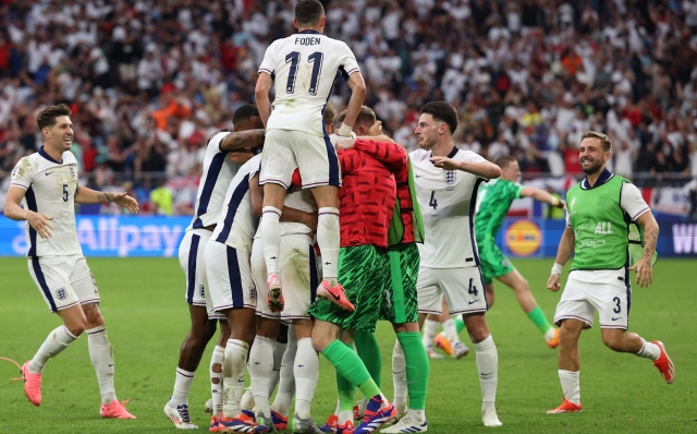 England's players celebrate their first goal during the UEFA Euro 2024 round of 16 football match between England and Slovakia at the Arena AufSchalke in Gelsenkirchen on June 30, 2024. (Photo by Adrian DENNIS / AFP)