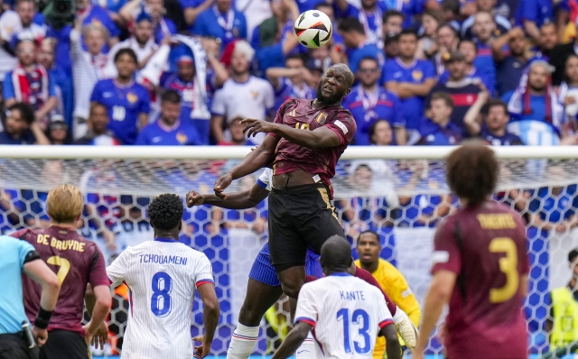 Belgium's Romelu Lukaku, top, heads the ball during a round of sixteen match between France and Belgium at the Euro 2024 soccer tournament in Dusseldorf, Germany, Monday, July 1, 2024. (AP Photo/Hassan Ammar)