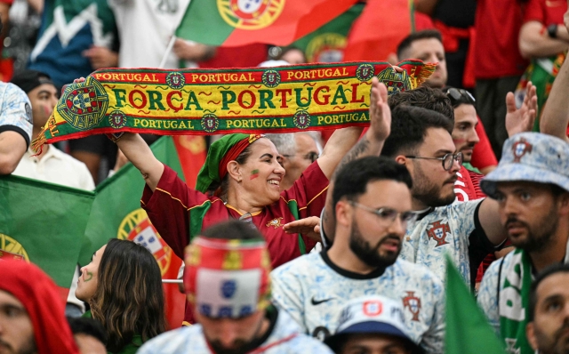 A Portugal's supporter holds a scarf ahead of the UEFA Euro 2024 round of 16 football match between Portugal and Slovenia at the Frankfurt Arena in Frankfurt am Main on July 1, 2024. (Photo by PATRICIA DE MELO MOREIRA / AFP)