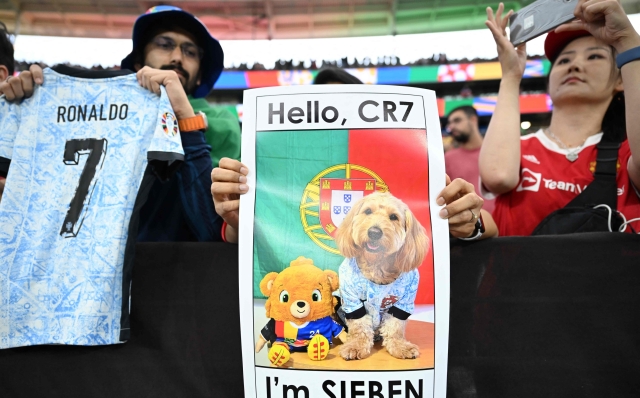 A Portugal's supporter holds a placard reading "Hello CR7, I'm 7" ahead of the UEFA Euro 2024 round of 16 football match between Portugal and Slovenia at the Frankfurt Arena in Frankfurt am Main on July 1, 2024. (Photo by Kirill KUDRYAVTSEV / AFP)