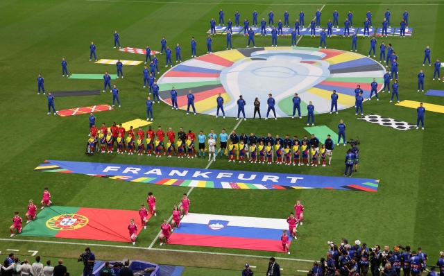 Portugal's players and Slovenia's players sing their national anthems ahead of the UEFA Euro 2024 round of 16 football match between Portugal and Slovenia at the Frankfurt Arena in Frankfurt am Main on July 1, 2024. (Photo by Daniel ROLAND / AFP)