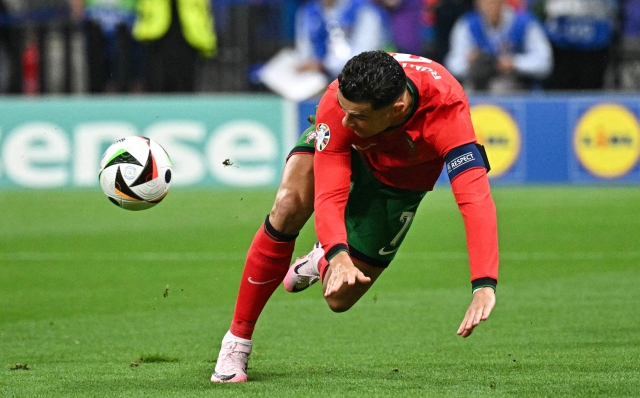 Portugal's forward #07 Cristiano Ronaldo falls on the pitch during the UEFA Euro 2024 round of 16 football match between Portugal and Slovenia at the Frankfurt Arena in Frankfurt am Main on July 1, 2024. (Photo by JAVIER SORIANO / AFP)