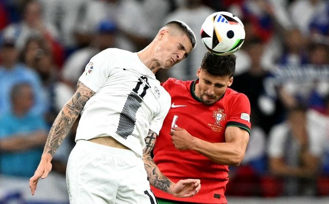 Slovenia's forward #11 Benjamin Sesko (L) and Portugal's defender #04 Ruben Dias jump for the ball during the UEFA Euro 2024 round of 16 football match between France and Belgium at the Duesseldorf Arena in Duesseldorf on July 1, 2024. (Photo by PATRICIA DE MELO MOREIRA / AFP)