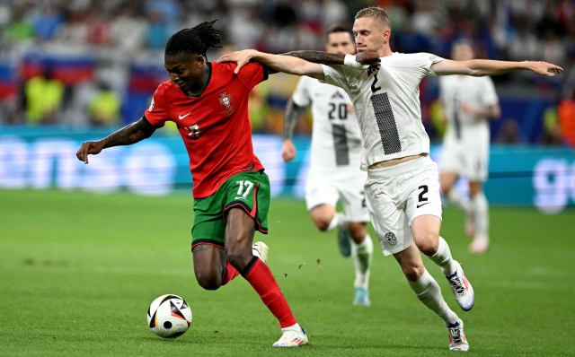 TOPSHOT - Portugal's forward #17 Rafael Leao (L) fights for the ball with  Slovenia's defender #02 Zan Karnicnik during the UEFA Euro 2024 round of 16 football match between Portugal and Slovenia at the Frankfurt Arena in Frankfurt am Main on July 1, 2024. (Photo by PATRICIA DE MELO MOREIRA / AFP)