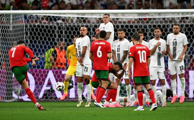 Portugal's forward #07 Cristiano Ronaldo (L) hits a free kick during the UEFA Euro 2024 round of 16 football match between Portugal and Slovenia at the Frankfurt Arena in Frankfurt am Main on July 1, 2024. (Photo by PATRICIA DE MELO MOREIRA / AFP)