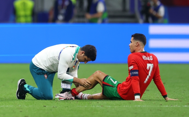 FRANKFURT AM MAIN, GERMANY - JULY 01: Cristiano Ronaldo of Portugal receives medical treatment as he waits for extra-time during the UEFA EURO 2024 round of 16 match between Portugal and Slovenia at Frankfurt Arena on July 01, 2024 in Frankfurt am Main, Germany. (Photo by Lars Baron/Getty Images)