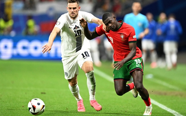 Slovenia's midfielder #10 Timi Elsnik (L)  fights for the ball with Portugal's defender #19 Nuno Mendes during the UEFA Euro 2024 round of 16 football match between Portugal and Slovenia at the Frankfurt Arena in Frankfurt am Main on July 1, 2024. (Photo by PATRICIA DE MELO MOREIRA / AFP)