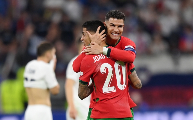 FRANKFURT AM MAIN, GERMANY - JULY 01: Cristiano Ronaldo and Joao Cancelo of Portugal celebrate following the team's victory in the penalty shoot out during the UEFA EURO 2024 round of 16 match between Portugal and Slovenia at Frankfurt Arena on July 01, 2024 in Frankfurt am Main, Germany. (Photo by Justin Setterfield/Getty Images)