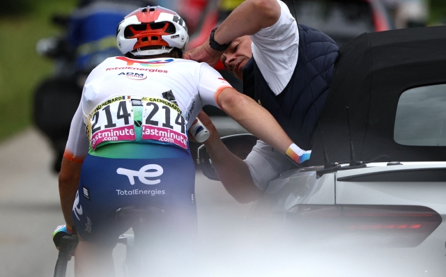 TotalEnergies team's French rider Thomas Gachignard seeks medical assistance from the medial car as he cycles during the 5th stage of the 111th edition of the Tour de France cycling race, 177,5 km between Saint-Jean-de-Maurienne and Saint-Vulbas, on July 3, 2024. (Photo by Anne-Christine POUJOULAT / AFP)